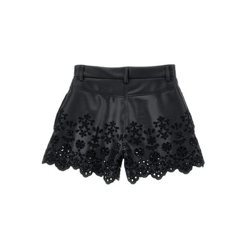 Shorts in ecopelle con ricamo floreale traforato